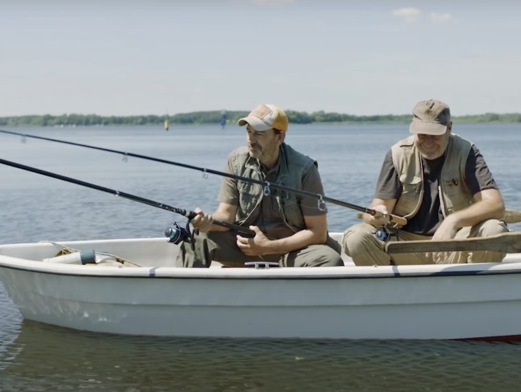 Zwei Fischer mit Angel im Boot auf einem See.
