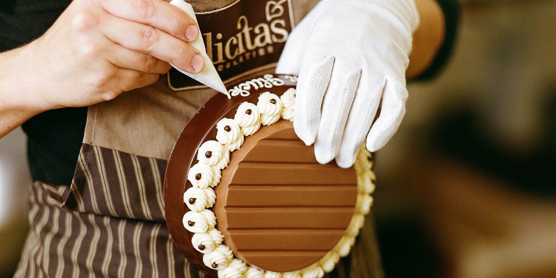 Eine Person verziert einen Schokoladensockel.